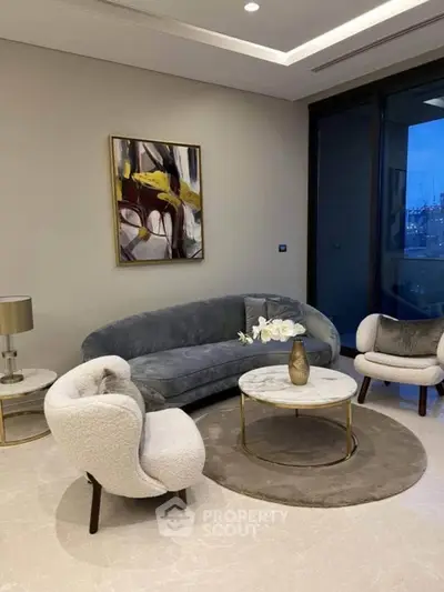 Elegant living room with modern furniture and abstract art, featuring a cozy ambiance.