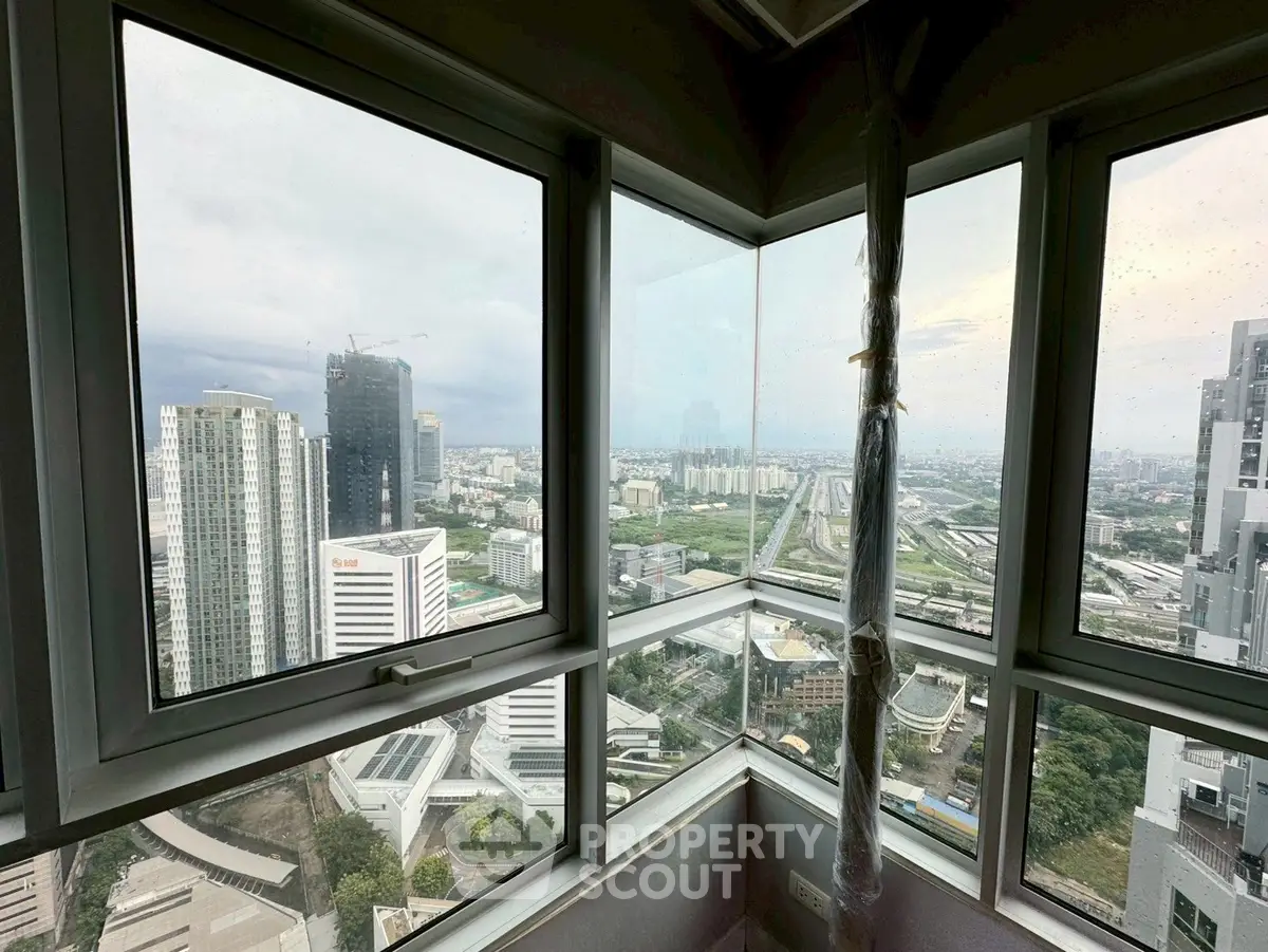 Stunning corner unit with panoramic city views from high-rise building.