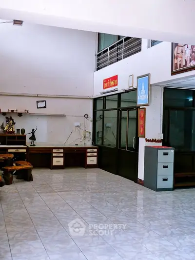 Spacious interior with tiled flooring and office furniture, ideal for versatile use.