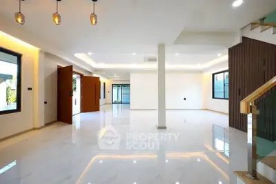 Spacious modern living room with elegant lighting and large windows in a luxury home.