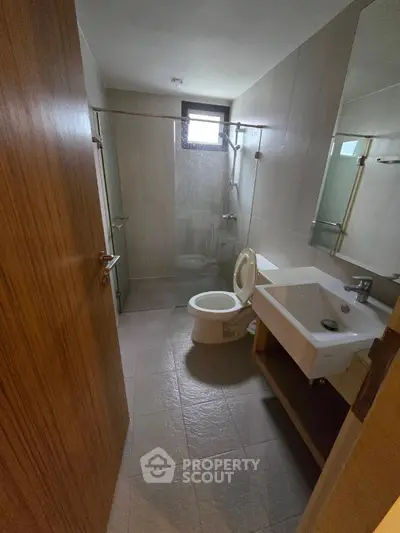 Modern bathroom with glass shower and sleek fixtures in a contemporary apartment.