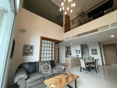 Spacious modern living room with high ceiling and elegant decor in a luxury apartment.
