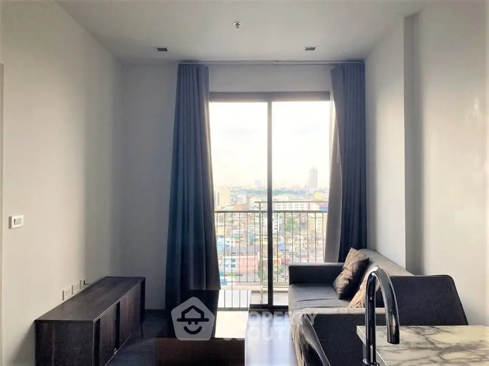 Modern living room with city view, featuring sleek furniture and large windows for natural light.