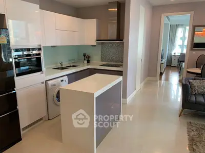 Modern kitchen with sleek design, featuring built-in appliances and a washing machine.