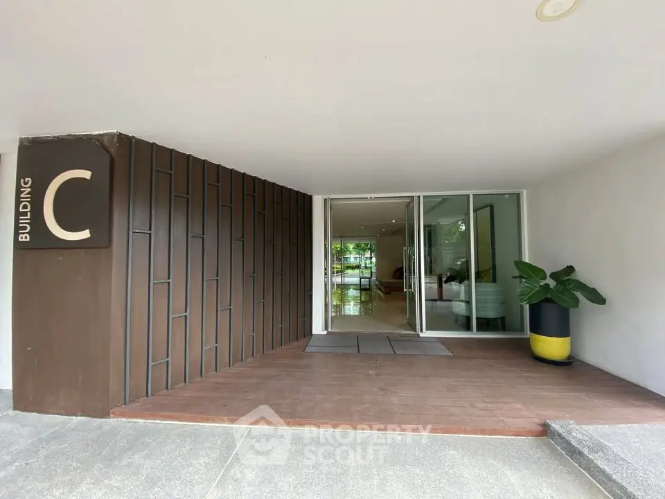 Modern building entrance with sleek design and greenery