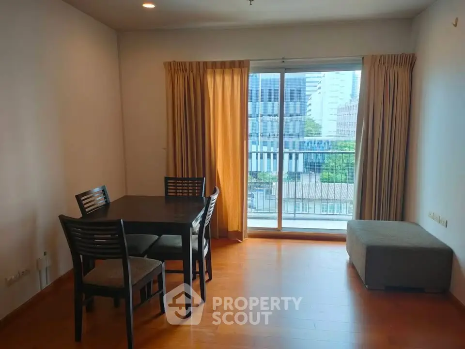 Spacious living room with dining area and city view balcony in modern apartment.