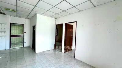 Spacious interior with tiled flooring and multiple doorways, ideal for customization.