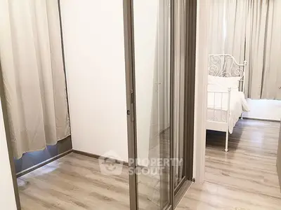 Modern bedroom with glass sliding doors and elegant white bed frame.