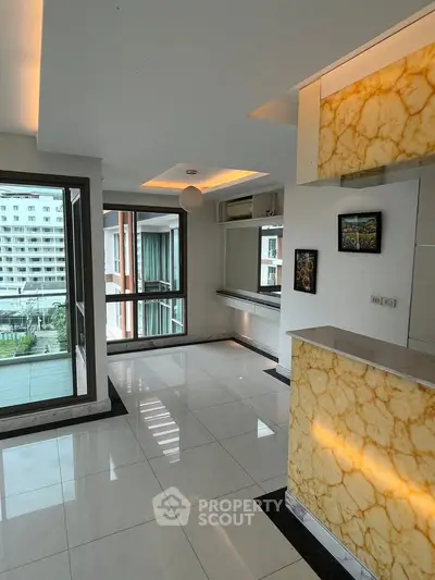 Modern apartment interior with marble accents and large windows offering a city view.