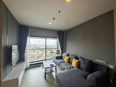 Modern living room with city view, stylish gray sofa, and large window for natural light.