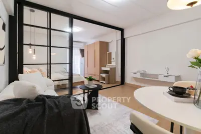 Modern open-plan living room with glass partition to cozy bedroom