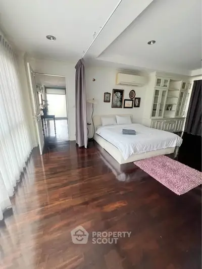 Spacious bedroom with elegant wooden flooring and modern decor