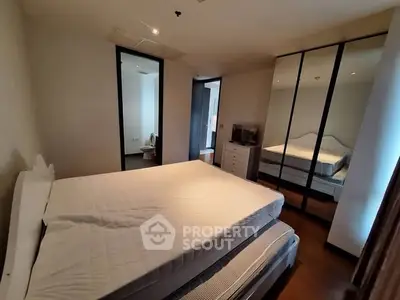 Spacious bedroom with mirrored wardrobe and modern decor