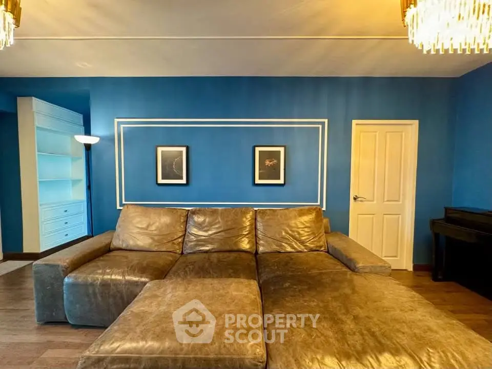 Luxurious living room with elegant blue walls and plush leather sofa