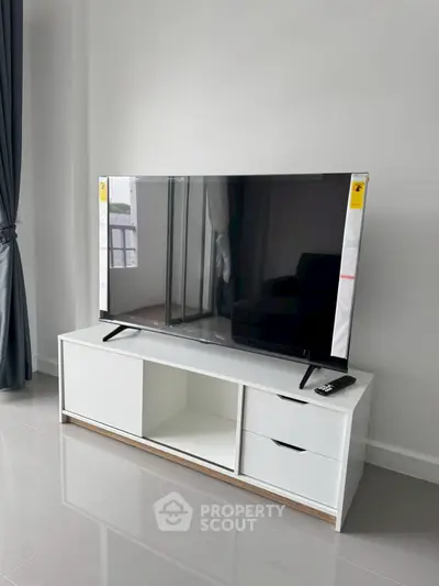 Modern living room with sleek TV setup and minimalist furniture design.