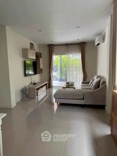 Spacious living room with modern decor and large windows offering natural light.