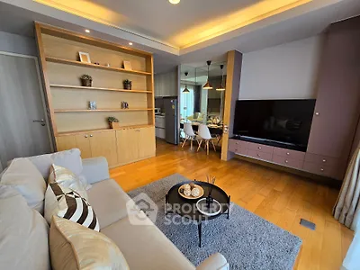 Modern living room with stylish decor and open layout, featuring cozy seating and elegant shelving.