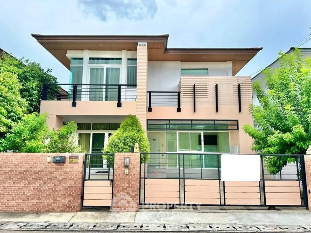 Modern two-story house with large windows and gated entrance