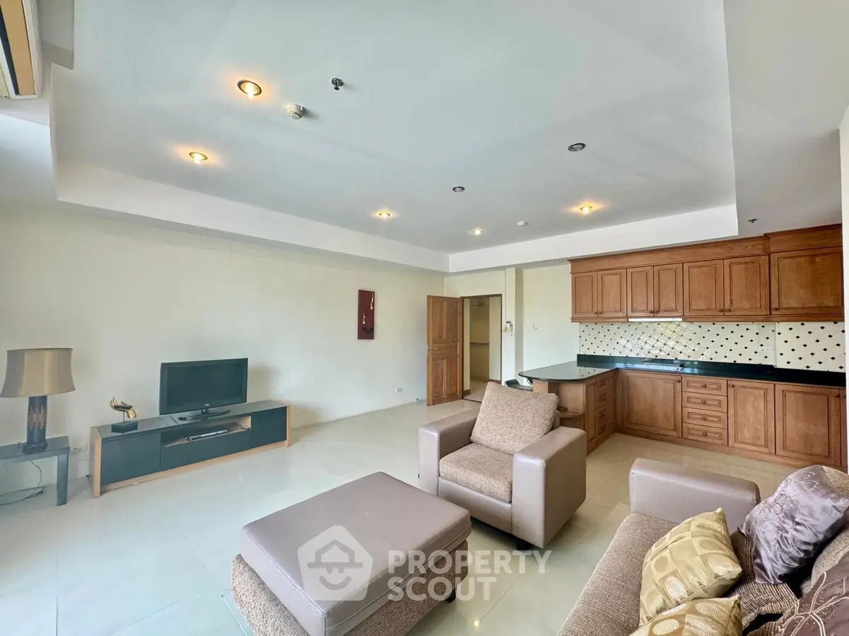 Spacious living room with modern furniture and open kitchen layout in a stylish apartment.