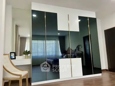 Modern bedroom with sleek mirrored wardrobe and elegant decor