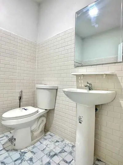Modern bathroom with white tiles and pedestal sink