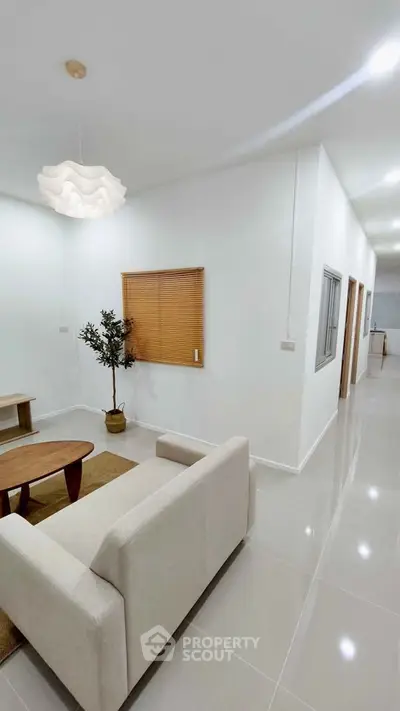 Modern living room with minimalist decor and neutral tones, featuring a cozy sofa and stylish lighting.