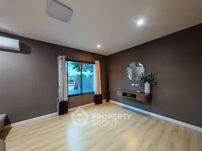Spacious living room with modern decor and large window offering scenic views.