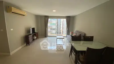 Spacious living room with modern furniture and large window view.