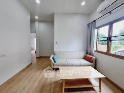 Modern living room with cozy sofa and wooden coffee table, bright natural light.