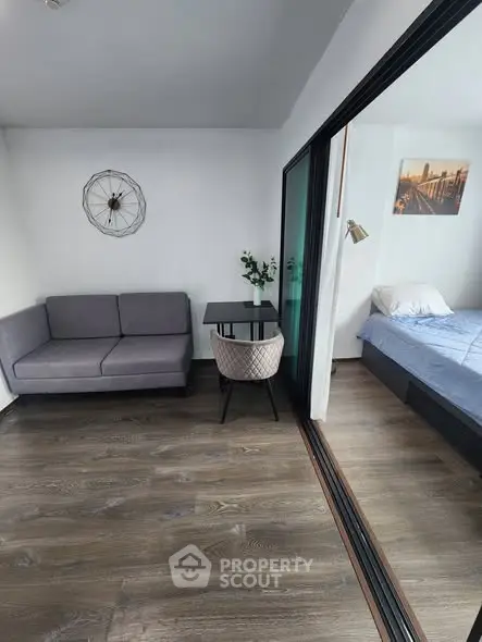 Modern studio apartment with sleek design, featuring a cozy living area and a comfortable bedroom.