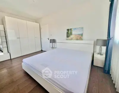 Spacious bedroom with modern white furniture and natural light
