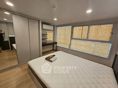 Modern bedroom with large windows and mirrored wardrobe