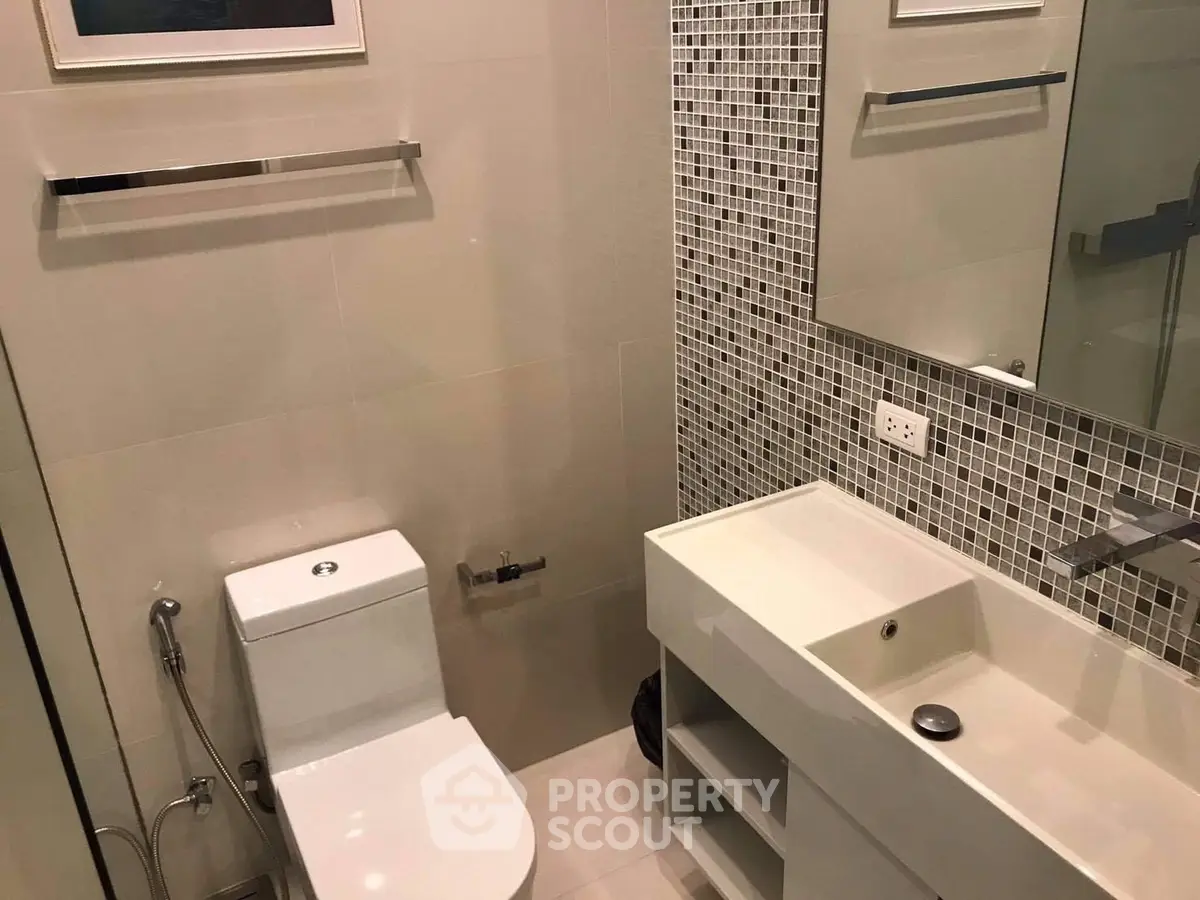 Modern bathroom with sleek fixtures and mosaic tile accents