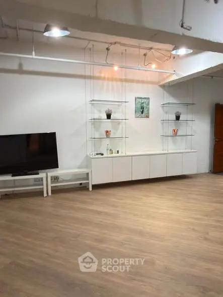 Spacious modern living room with sleek wooden flooring and minimalist decor