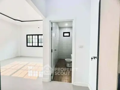 Modern interior with bright living area and adjacent bathroom in a stylish home.