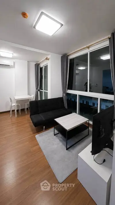 Modern living room with sleek furniture and large windows in a stylish apartment.
