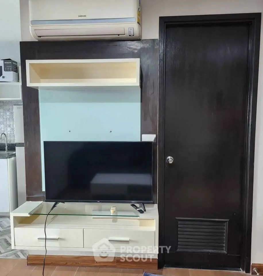 Modern living room with sleek TV unit and air conditioning, perfect for cozy entertainment.