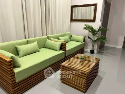 Modern living room with stylish wooden furniture and green cushions, perfect for a cozy and elegant home.