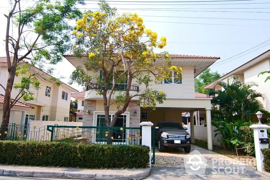 Charming two-story house with lush garden and spacious driveway in a serene neighborhood.