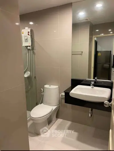 Modern bathroom with sleek fixtures and shower in contemporary apartment.