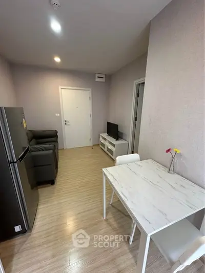 Modern apartment interior with cozy living room and dining area, featuring sleek furniture and neutral tones.