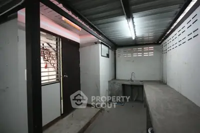 Industrial-style utility room with concrete countertops and metal ceiling, ideal for storage or workshop use.