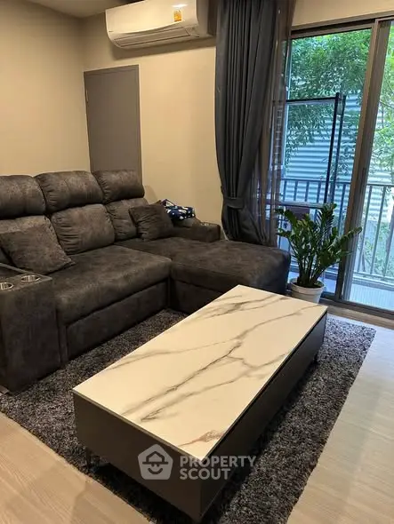 Modern living room with plush sofa, marble coffee table, and balcony view.
