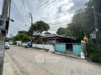 Charming suburban house with gated entrance and lush greenery, perfect for family living.