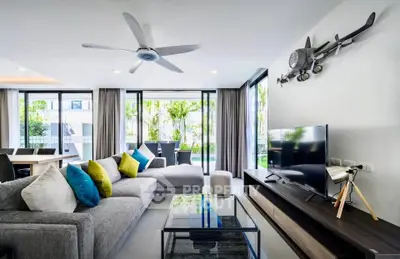 Modern living room with stylish decor and large windows overlooking greenery.