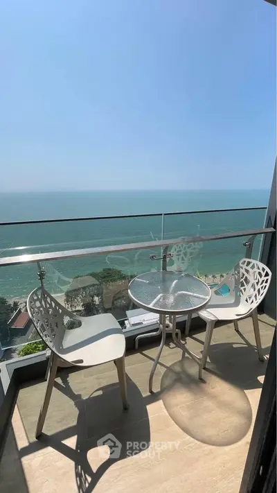 Stunning ocean view from a modern balcony with stylish seating, perfect for relaxation.