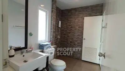 Modern bathroom with stylish stone wall and sleek fixtures