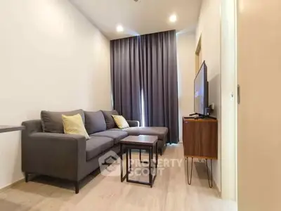 Modern living room with stylish gray sofa and flat-screen TV, perfect for relaxation.