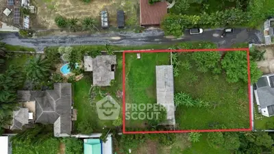Aerial view of a spacious plot of land with lush greenery, ideal for development in a serene neighborhood.