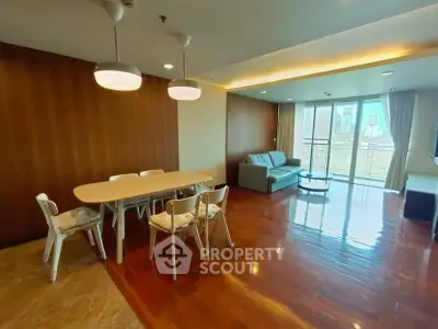 Spacious living room with wooden flooring and modern furniture in a bright apartment.